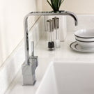 Polished chrome square single-handle kitchen faucet.