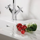 Polished chrome kitchen faucet with dual handles.