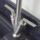 Silver kitchen faucet with red hot and cold handles.