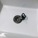Chrome sink strainer with stopper in ceramic sink