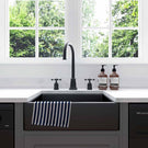 Black farmhouse sink with a black faucet.