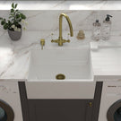 White sink with a gold-toned high-arc faucet.