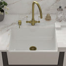 White sink with a gold-toned high-arc faucet.