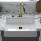 White farmhouse sink with gold kitchen faucet