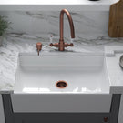 “White ceramic single bowl kitchen sink with copper mixer tap