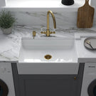 Modern white ceramic sink with brass faucet
