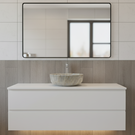Bathroom vanity with a marble sink and mirror on tiled walls.