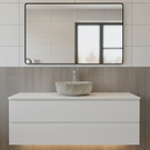 Bathroom vanity with a marble sink and mirror on tiled walls.