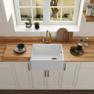 Modern kitchen with a white farmhouse sink, wooden countertop, and window view.
