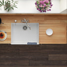 Modern kitchen with a white sink, wooden countertop, and decorative elements.