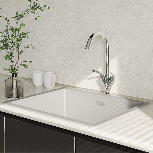 Modern kitchen sink with faucet and decorative elements on a light countertop.