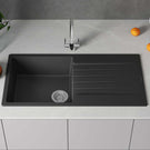 Black kitchen sink with faucet on a gray countertop