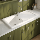 Kitchen with green cabinets, white sink, and light gray countertop.