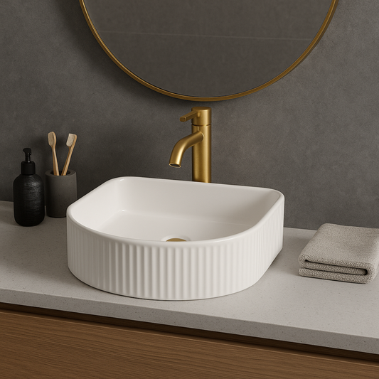 Bathroom vanity with white sink, gold faucet, and round mirror.