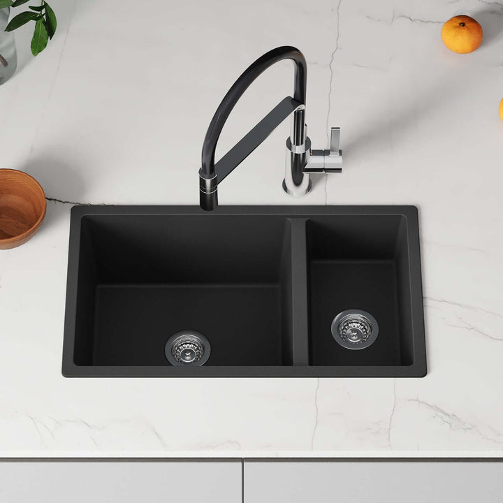 Black kitchen sink with a modern faucet on a white countertop.