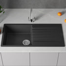 Black kitchen sink with faucet on a gray countertop