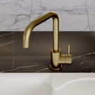 Gold faucet on a marble countertop with a neutral background