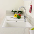 Kitchen sink with vegetables and a knife on a countertop